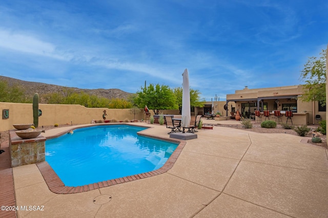 view of swimming pool with a patio area, a mountain view, and an outdoor bar