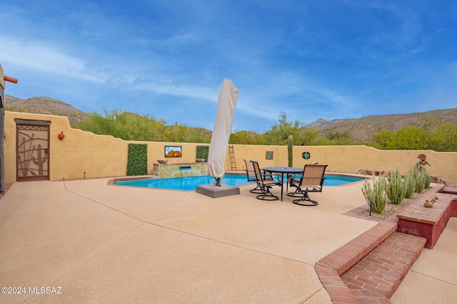 view of swimming pool with a mountain view and a patio