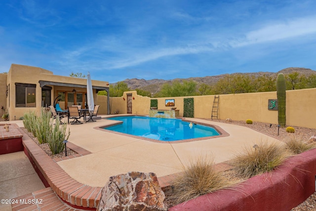 view of pool with a mountain view and a patio area