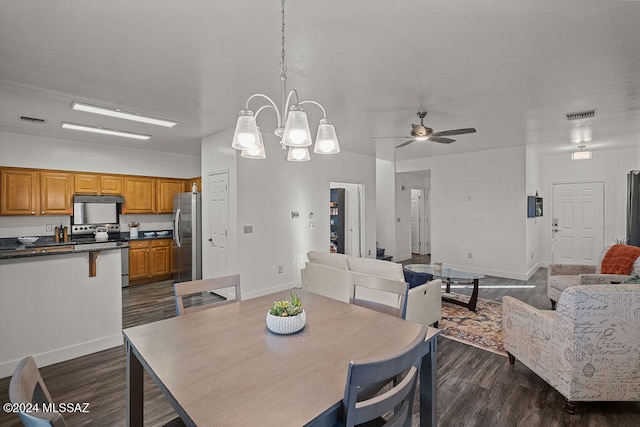 dining area featuring ceiling fan with notable chandelier and dark hardwood / wood-style flooring