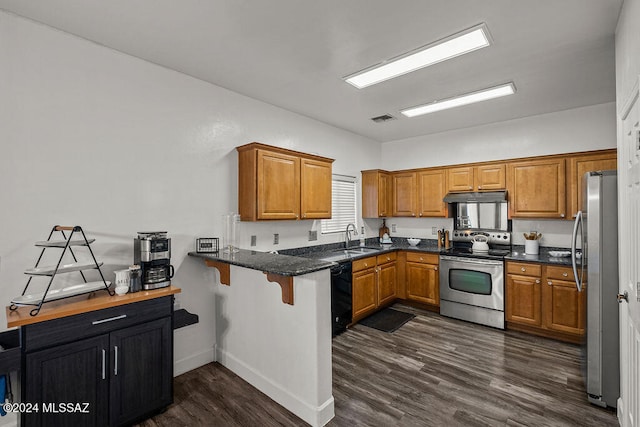 kitchen featuring kitchen peninsula, appliances with stainless steel finishes, dark hardwood / wood-style flooring, sink, and dark stone countertops