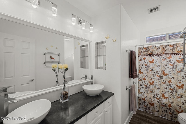 bathroom featuring hardwood / wood-style floors, vanity, curtained shower, and toilet