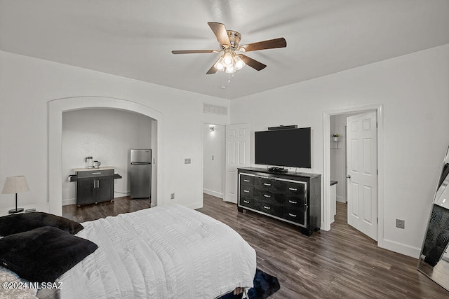 bedroom featuring stainless steel refrigerator, ceiling fan, and dark wood-type flooring