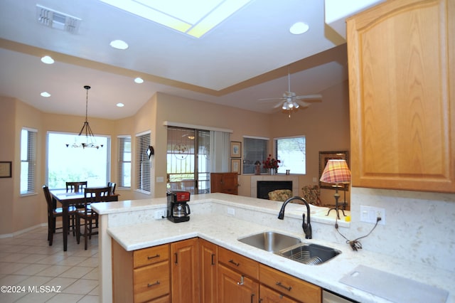 kitchen with backsplash, kitchen peninsula, sink, and a wealth of natural light