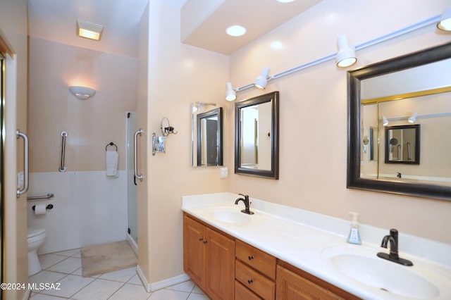 bathroom with tile patterned flooring, vanity, toilet, and a shower with shower door