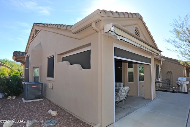 view of property exterior featuring cooling unit and a patio area