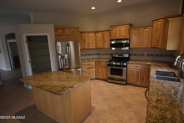 kitchen featuring light tile patterned flooring, stainless steel appliances, stone countertops, and sink