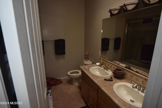 bathroom featuring vanity, a shower with door, tile patterned floors, and toilet