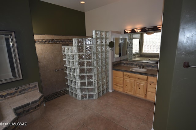 bathroom with tile patterned floors, a bath, a walk in shower, and vanity