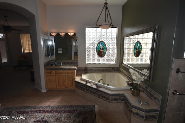 bathroom featuring tile patterned floors, vanity, and tiled bath