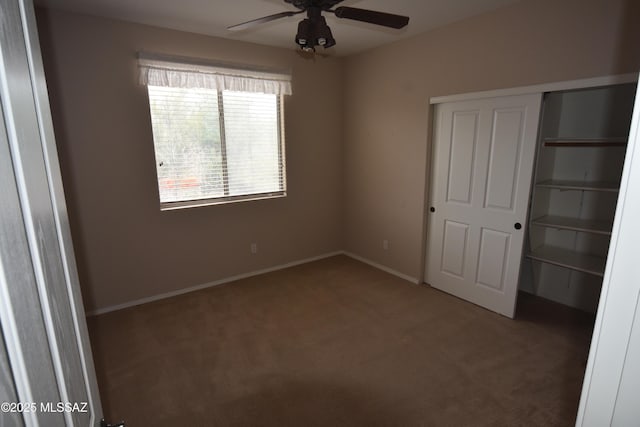 unfurnished bedroom with baseboards, a closet, carpet floors, and a ceiling fan