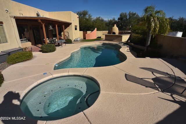 view of pool with an in ground hot tub and a patio