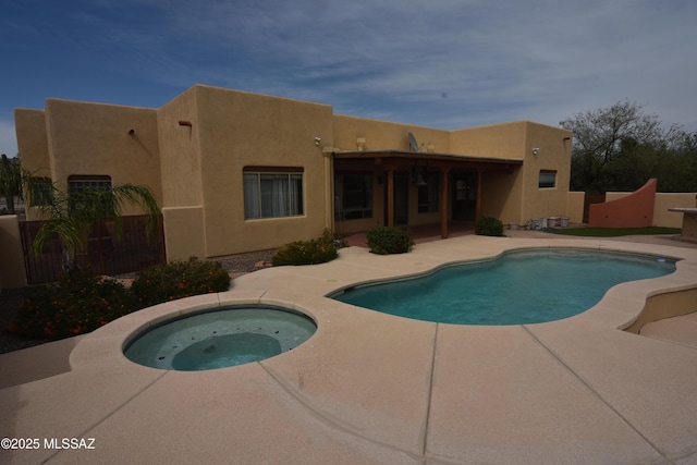 pool with fence, an in ground hot tub, and a patio