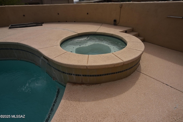 view of pool featuring an in ground hot tub