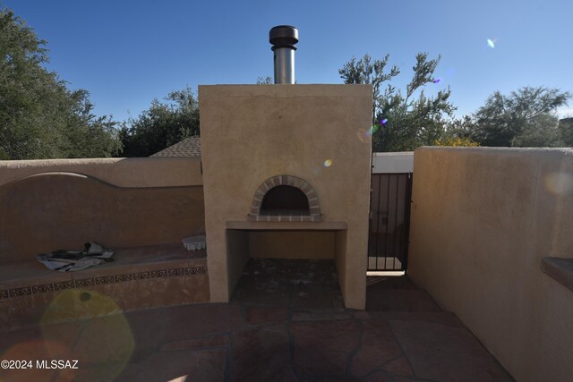 view of patio with a grill, exterior fireplace, and an outdoor kitchen