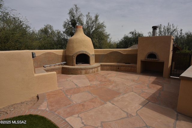 view of patio with exterior fireplace