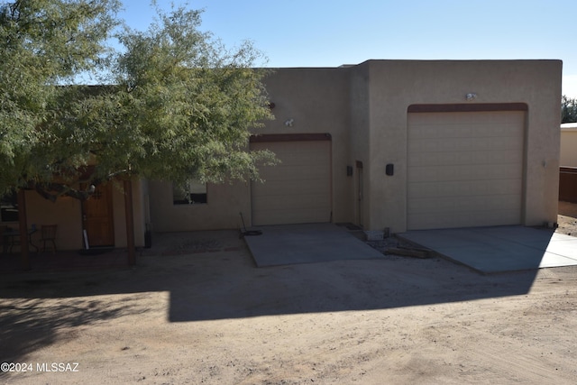 exterior space with stucco siding, an attached garage, and concrete driveway