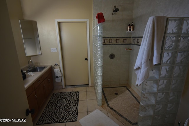 bathroom with tiled shower, vanity, and tile patterned flooring