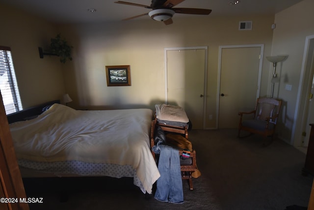 carpeted bedroom featuring a ceiling fan and visible vents