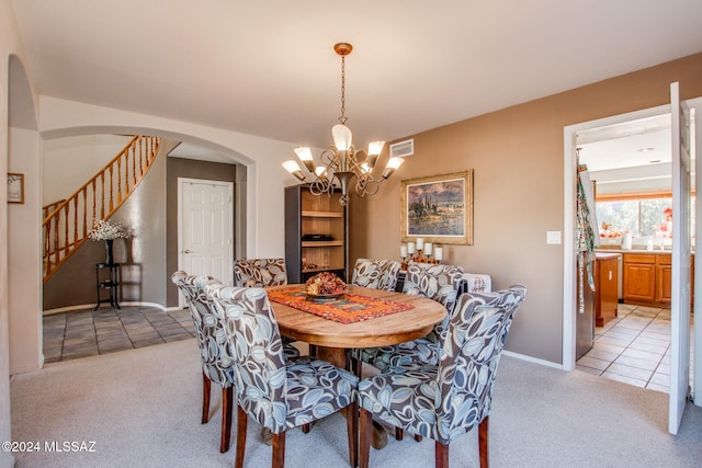 carpeted dining room featuring a notable chandelier