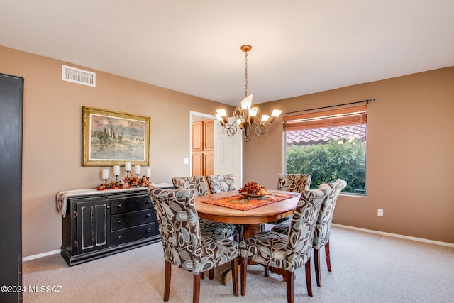 dining area with light colored carpet and a chandelier