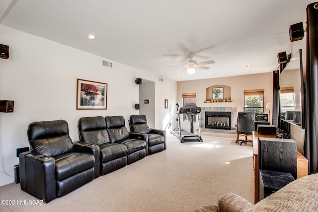 carpeted living room with ceiling fan and a fireplace