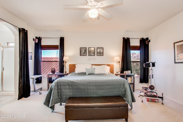 carpeted bedroom with ceiling fan and multiple windows