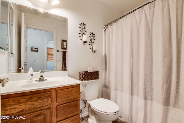 bathroom with a shower with shower curtain, vanity, and toilet