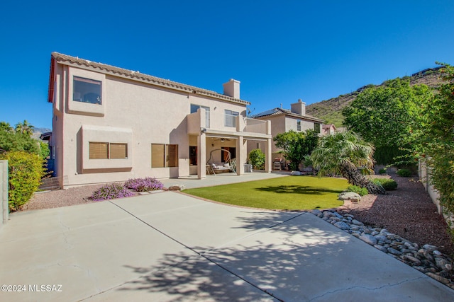 back of house featuring a lawn and a patio