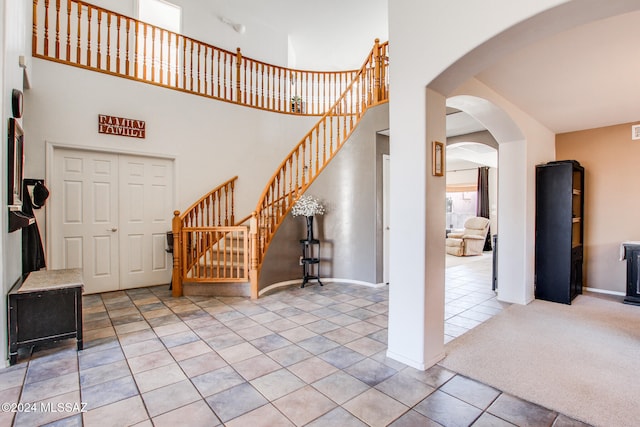 carpeted entrance foyer with a high ceiling