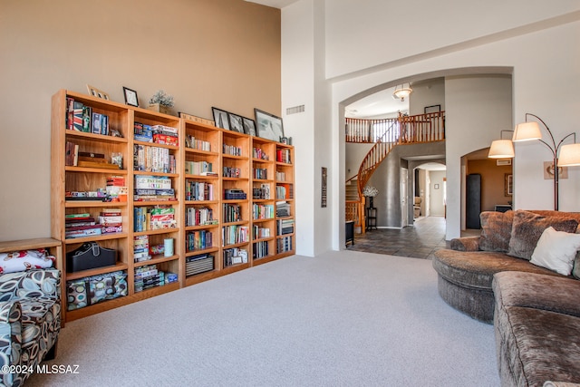 living area with carpet and a towering ceiling