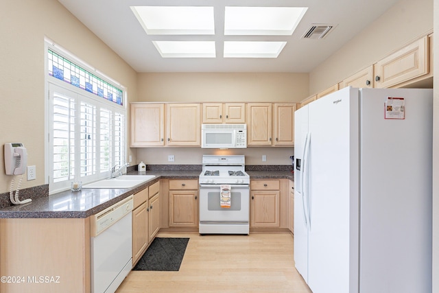 kitchen with light brown cabinets, white appliances, light hardwood / wood-style floors, and sink