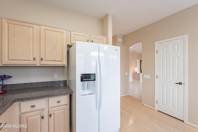 kitchen featuring light brown cabinetry, light hardwood / wood-style flooring, and white fridge with ice dispenser