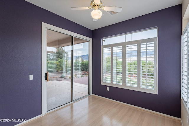 empty room with ceiling fan and light hardwood / wood-style floors