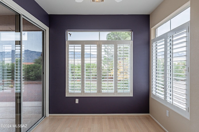 empty room with ceiling fan and light hardwood / wood-style floors