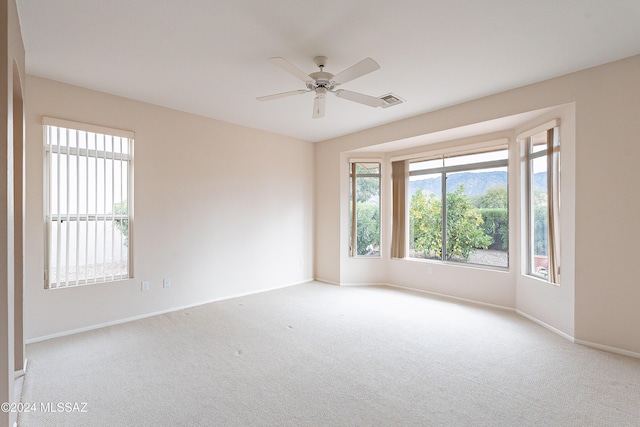 empty room featuring light carpet and ceiling fan