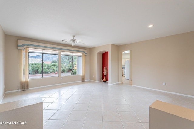 tiled spare room with ceiling fan