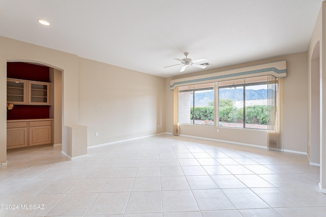 empty room with ceiling fan and light tile patterned floors