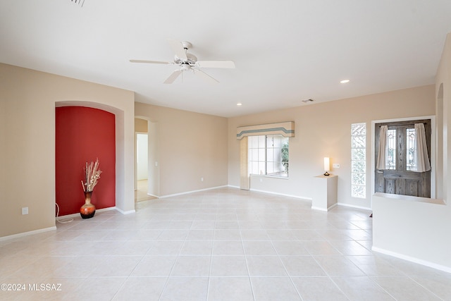 tiled empty room featuring plenty of natural light and ceiling fan