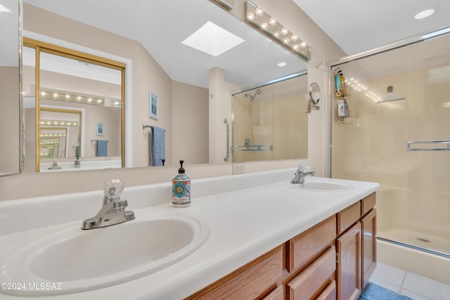 bathroom featuring tile patterned floors, vanity, a shower with shower door, and a skylight