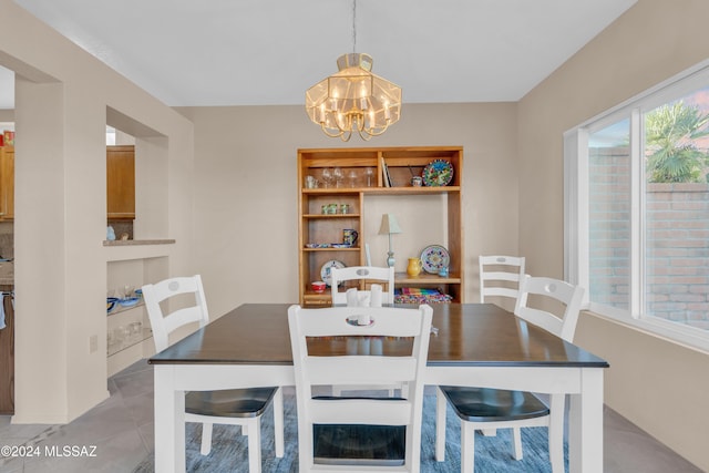 tiled dining room with a chandelier