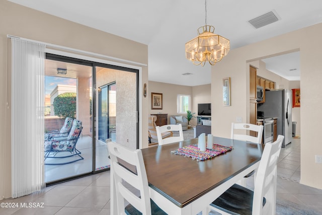 dining room with light tile patterned flooring and an inviting chandelier