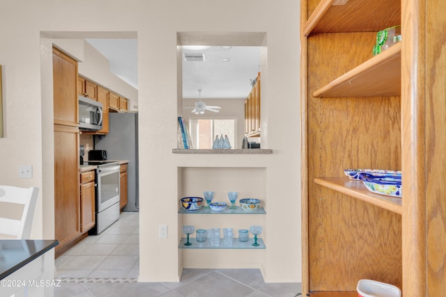 kitchen featuring ceiling fan, electric stove, and light tile patterned floors