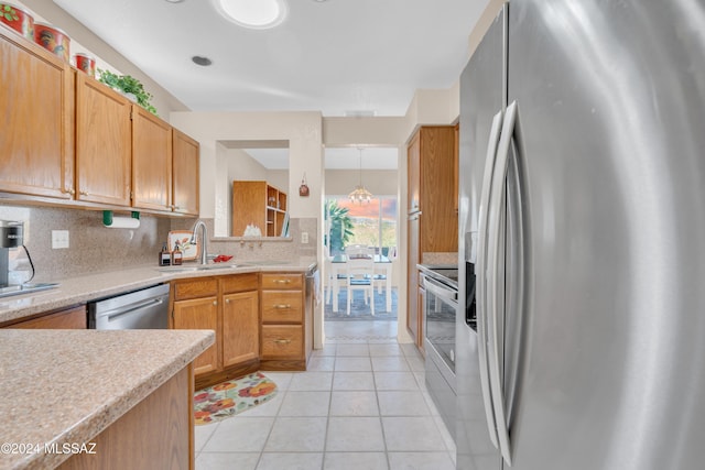 kitchen with tasteful backsplash, sink, light tile patterned floors, and appliances with stainless steel finishes