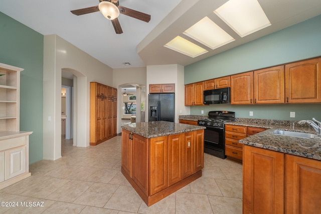 kitchen with sink, a kitchen island, ceiling fan, and black appliances