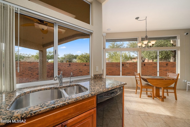 kitchen featuring dishwasher, sink, an inviting chandelier, dark stone counters, and light tile patterned floors