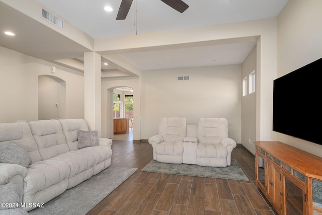 living room featuring ceiling fan and dark wood-type flooring