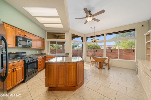 kitchen featuring hanging light fixtures, a center island, plenty of natural light, and black appliances