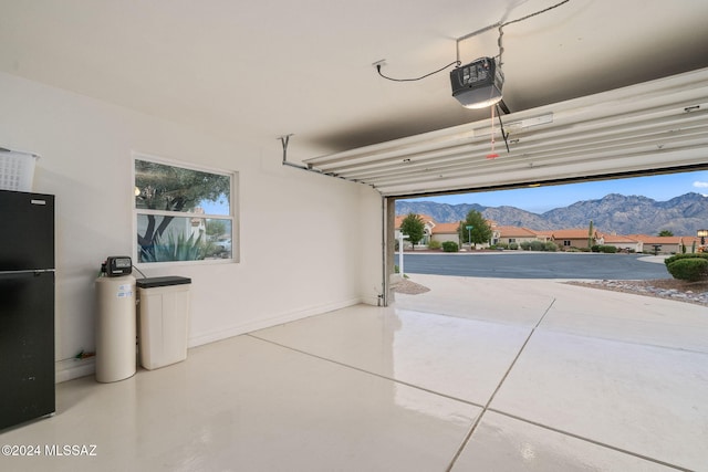 garage with a mountain view, a garage door opener, and black refrigerator