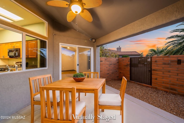 patio terrace at dusk featuring ceiling fan